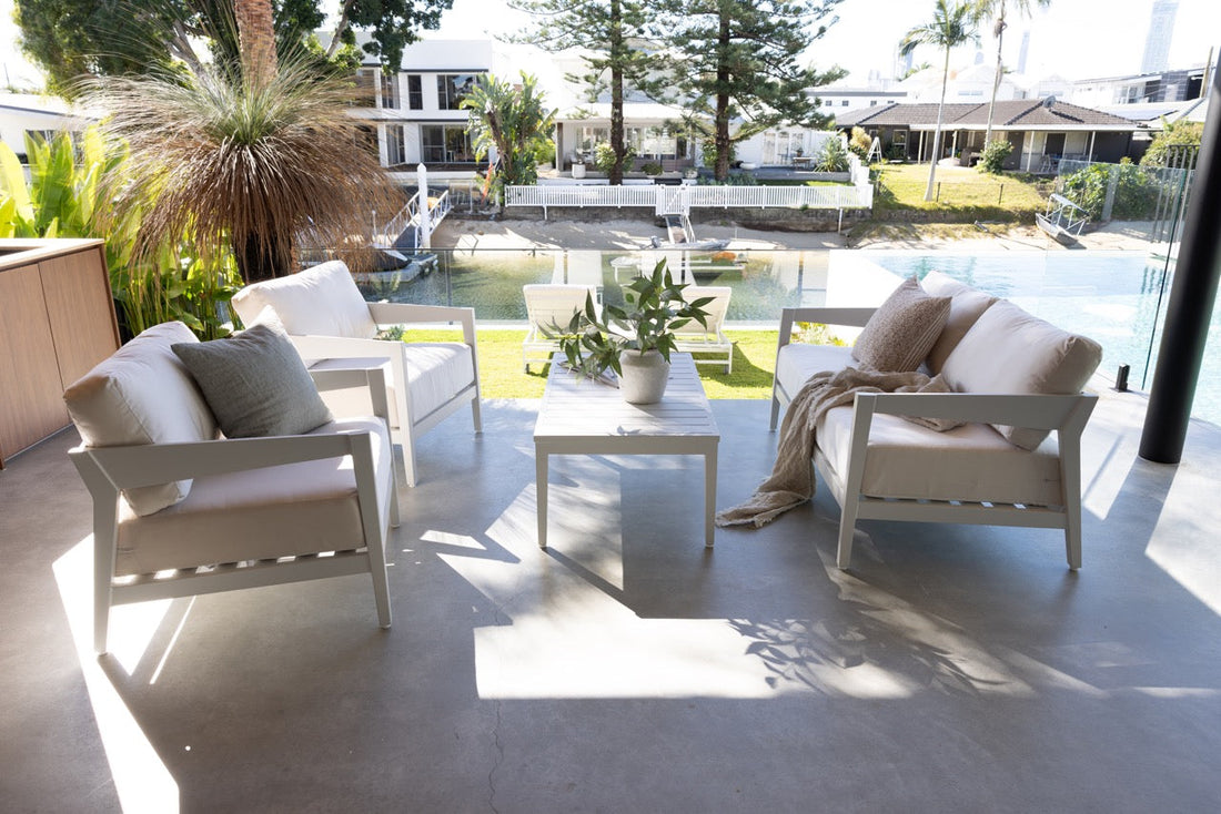 A stylish patio with comfortable outdoor furniture, surrounded by lush greenery