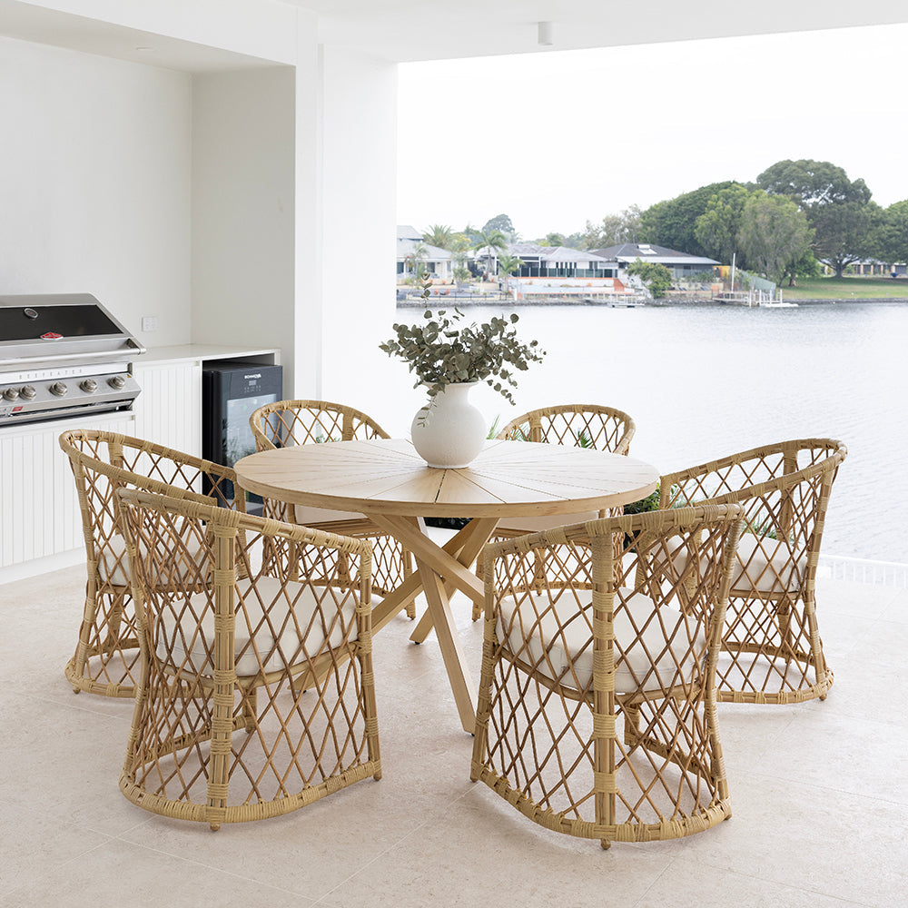 Stylish outdoor patio featuring high-quality wicker furniture with cushions and a scenic backdrop