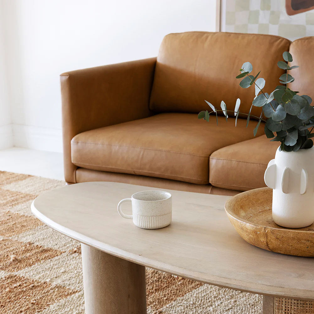 A compact living room with a modern nesting coffee table, soft lighting, and minimalist deco